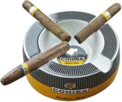 Round yellow ceramic ashtray with 4 cigar rests, sitting on a patio table with cigars resting on the rim.