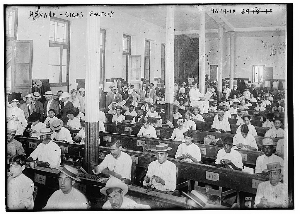 Historic black-and-white photograph of cigar rollers inside a Havana factory